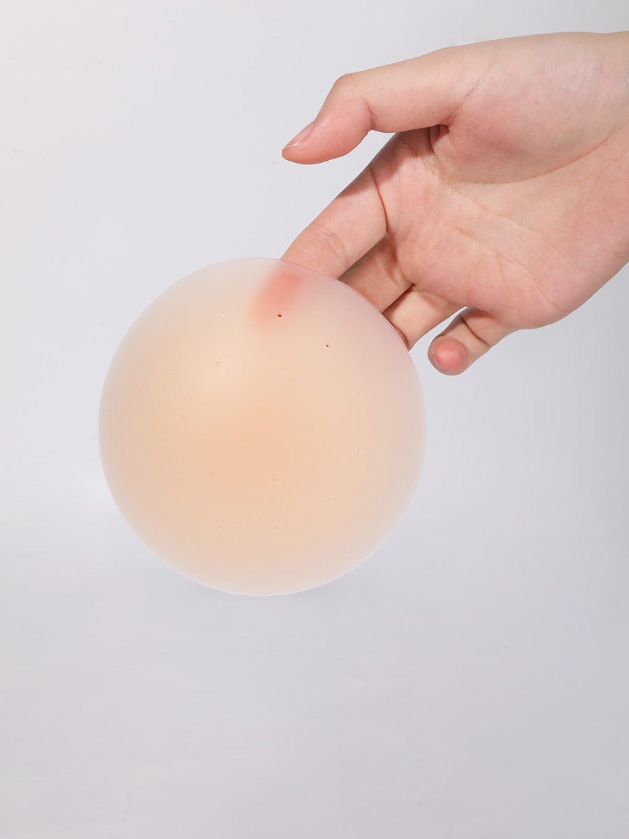 Invisible Nipple Covers in nude – held between fingers