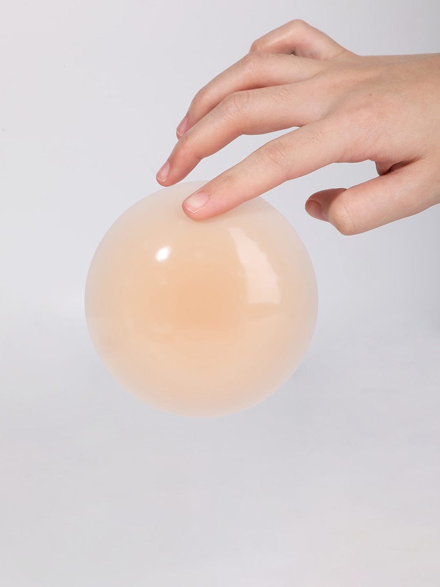 Invisible Nipple Covers in nude – held between fingers