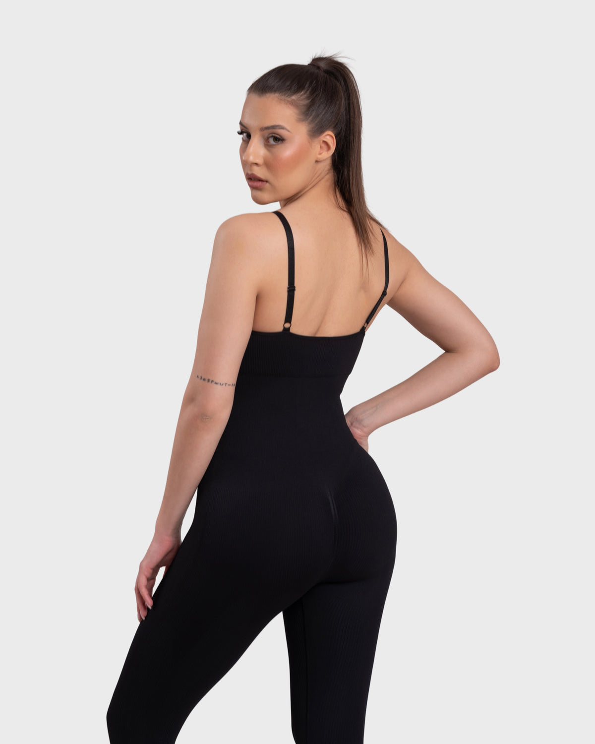 Ribbed Sculpting Jumpsuit in black – back three-quarter view