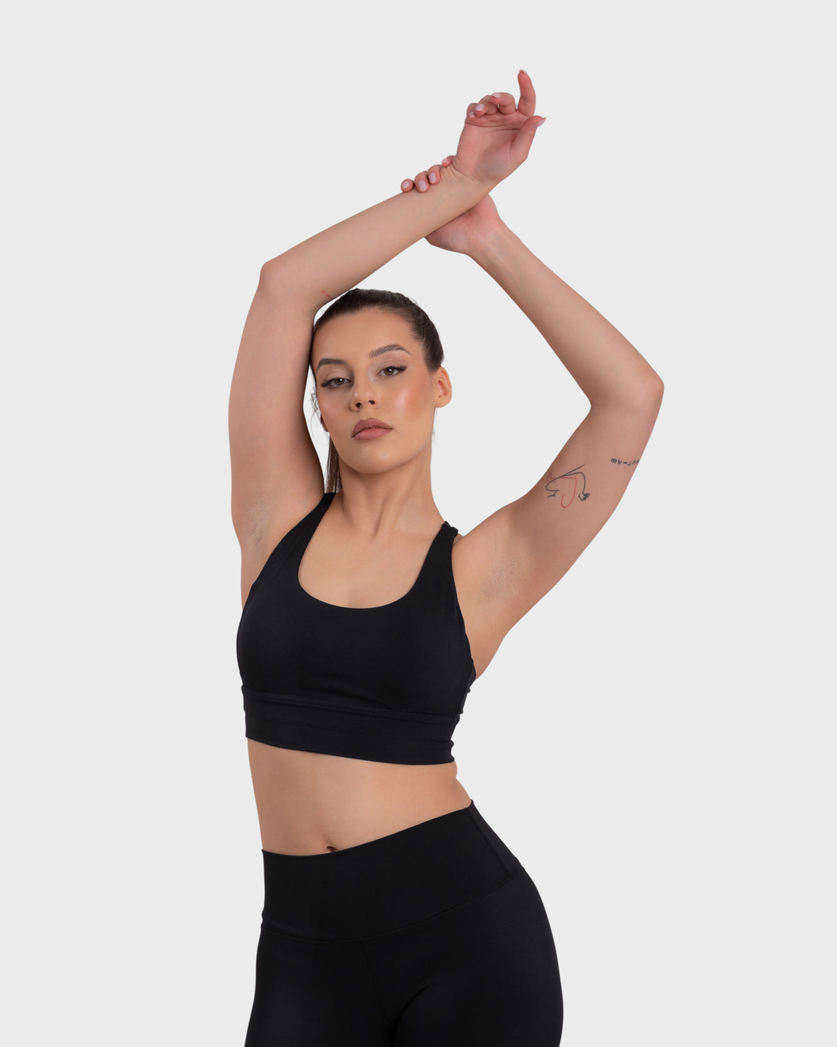 Evolve Active Sports Bra in black – model posing with arms raised