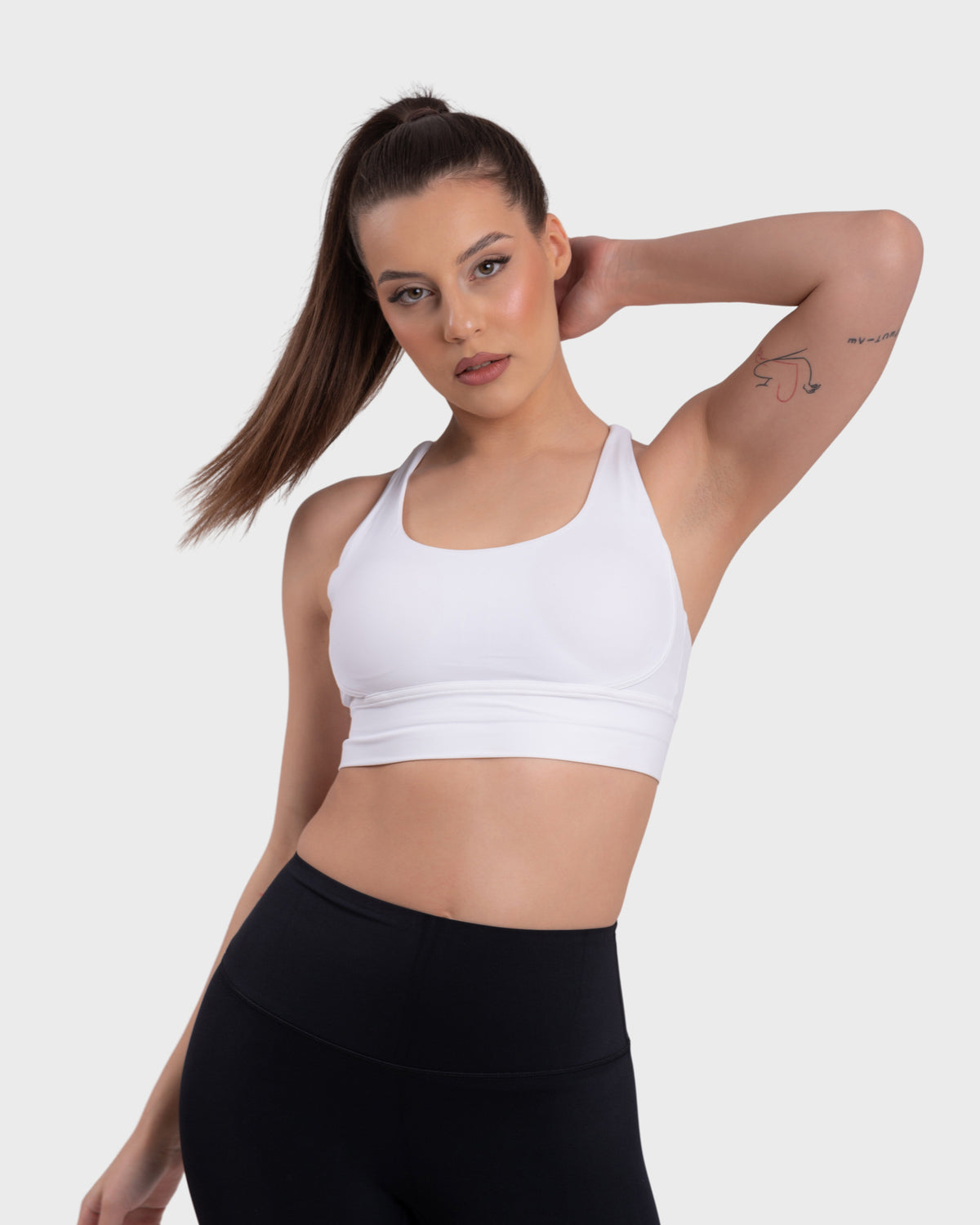 Evolve Active Sports Bra in white – model posing with arms raised